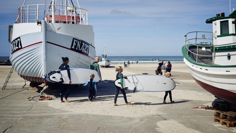 Familie mit Surfbrettern am Strand von Løkken in Nordjütland