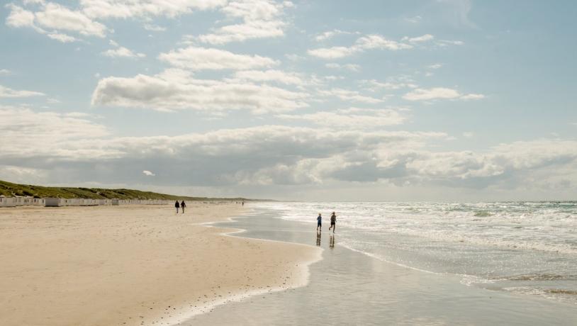 Kinder spielen am breiten Sandstrand von Løkken in Nordjütland an der Dänischen Nordsee