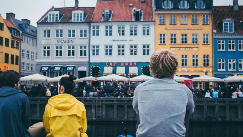 People sitting by the dock in Nyhavn, Copenhagen