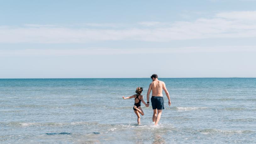 Bild von einem Vater und Sohn im Meer beim Palmestranden