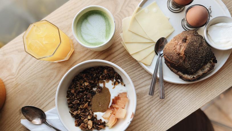 A breakfast spread of buns, eggs, matcha latte and porridge at café Lido in copenhagen.