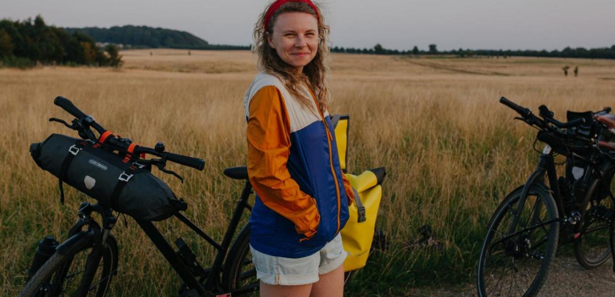 A lady stands with a bike in Hindsgavl National Park, Denmark