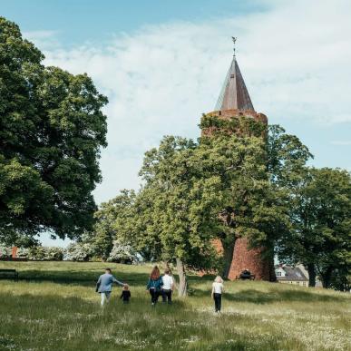 Een familie loopt naar Danmarks Borgcenter met de Gåsetårnet uitzichttoren