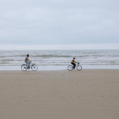Familie fährt Fahrrad am Strand der dänischen Nordseeküste