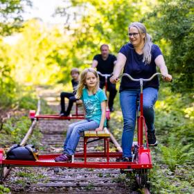 Een familie is aan het spoorfietsen in Sønderjylland